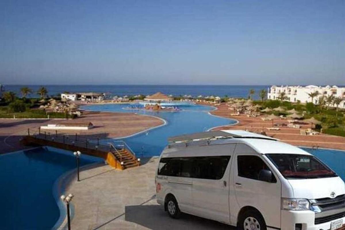 sebuah van putih diparkir di tempat parkir di sebelah pantai