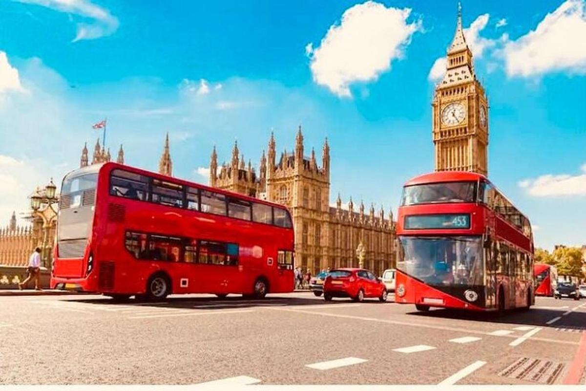 a red double decker bus driving past the big ben clock tower