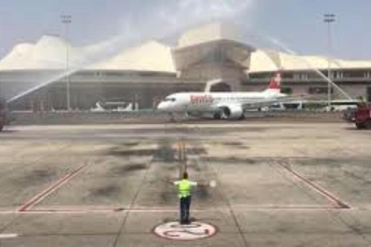 a man standing on an airport tarmac with an airplane
