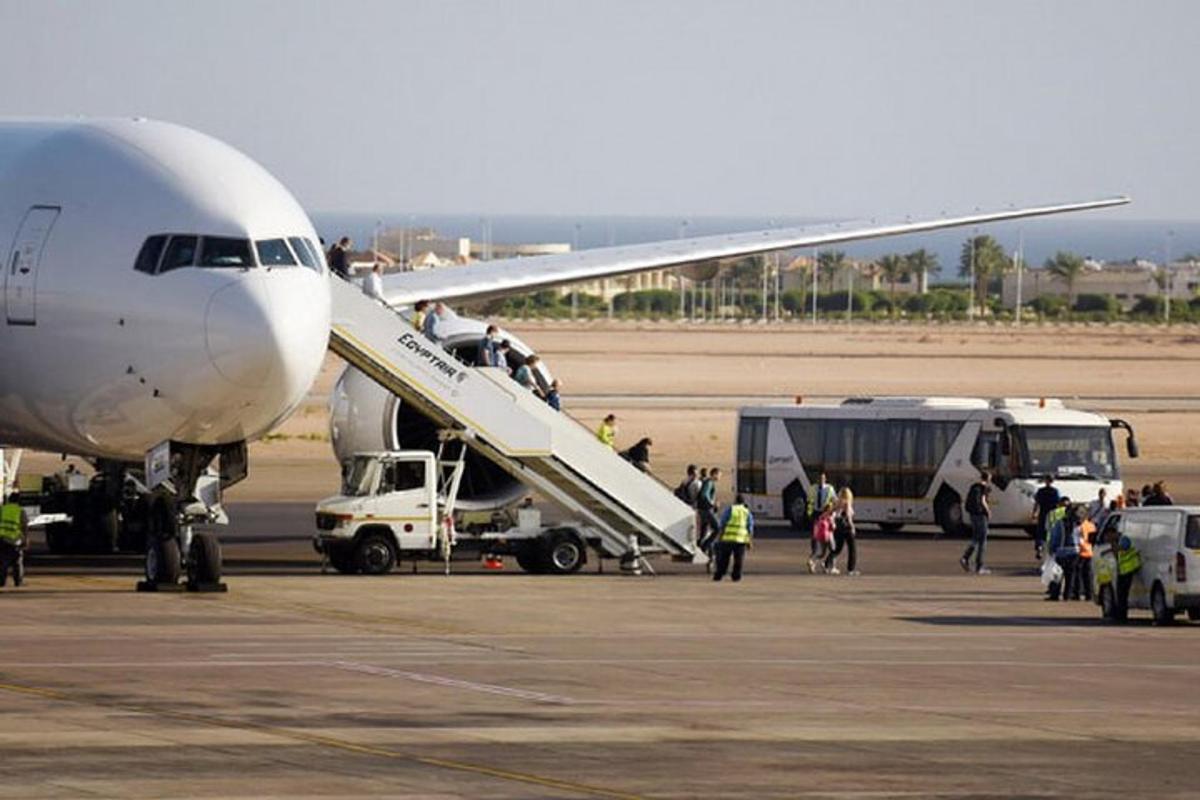 un grup de persones baixant d'un avió