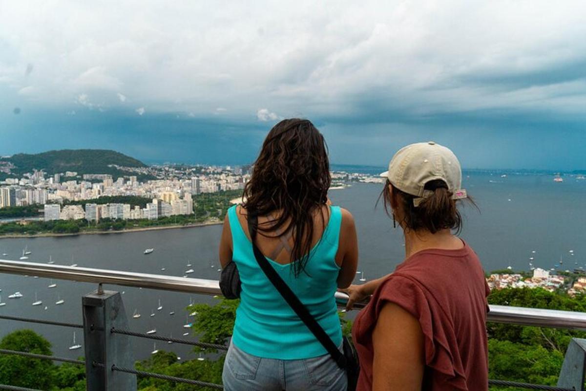 Dvě ženy stojící na balkóně a dívající se na vodu