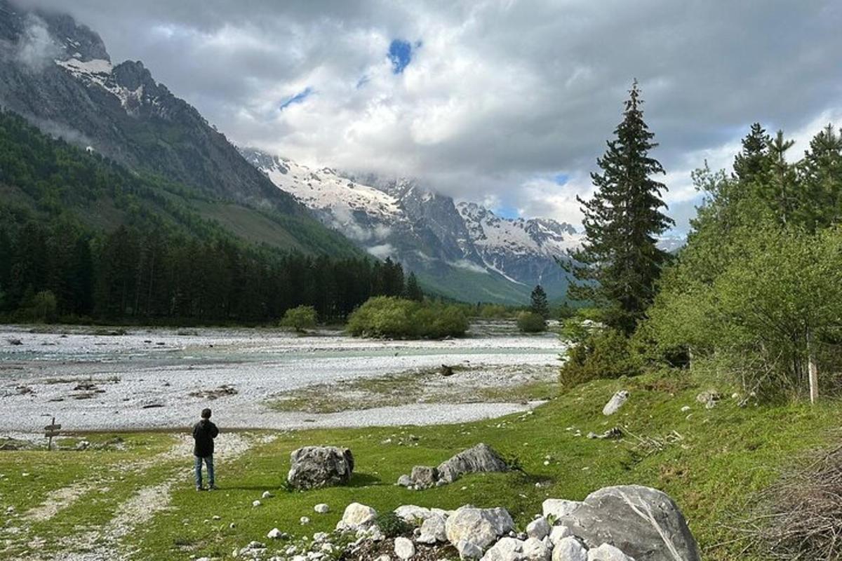 una persona parada en un campo junto a un río