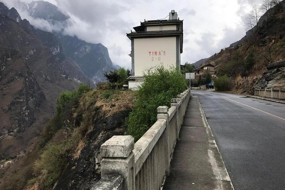 a road with a building on the side of a mountain