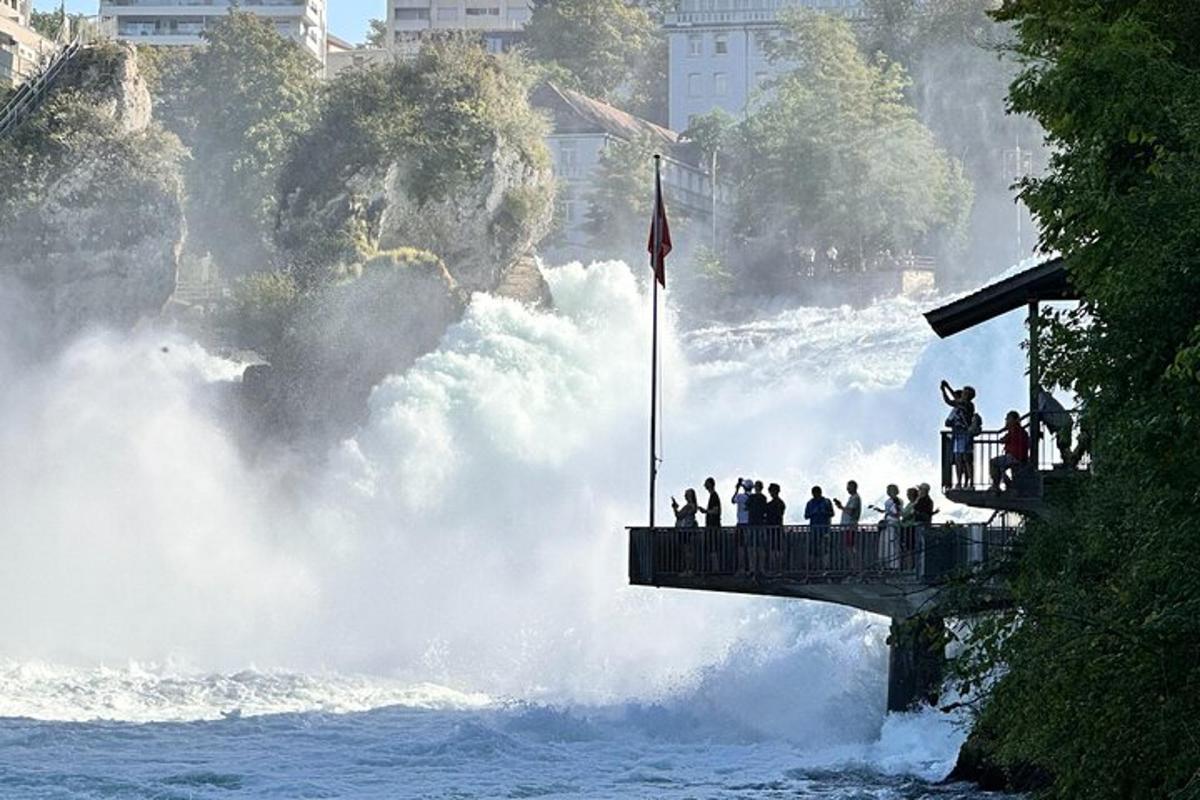 eine Gruppe von Menschen steht auf einer Brücke über einem reißenden Fluss