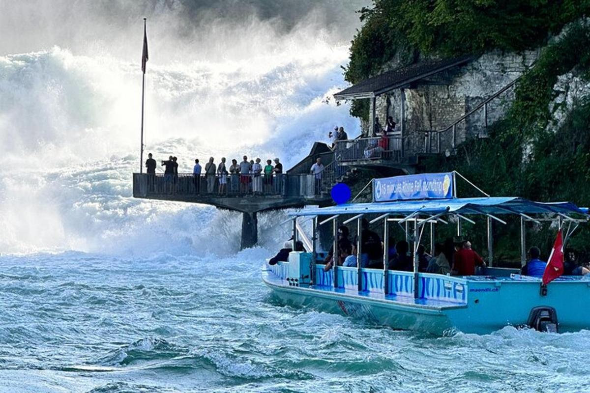 ein Boot im Wasser in der Nähe eines großen Wasserfalls