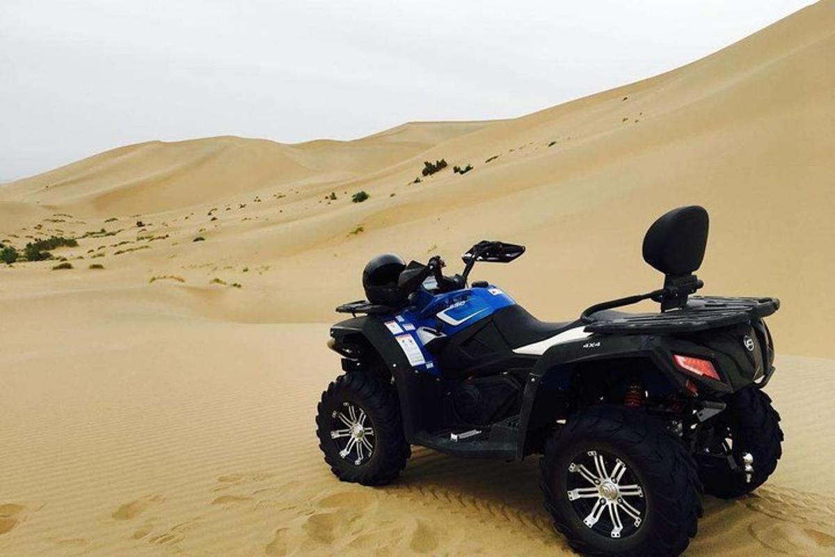 Una motocicleta estacionada en la arena del desierto