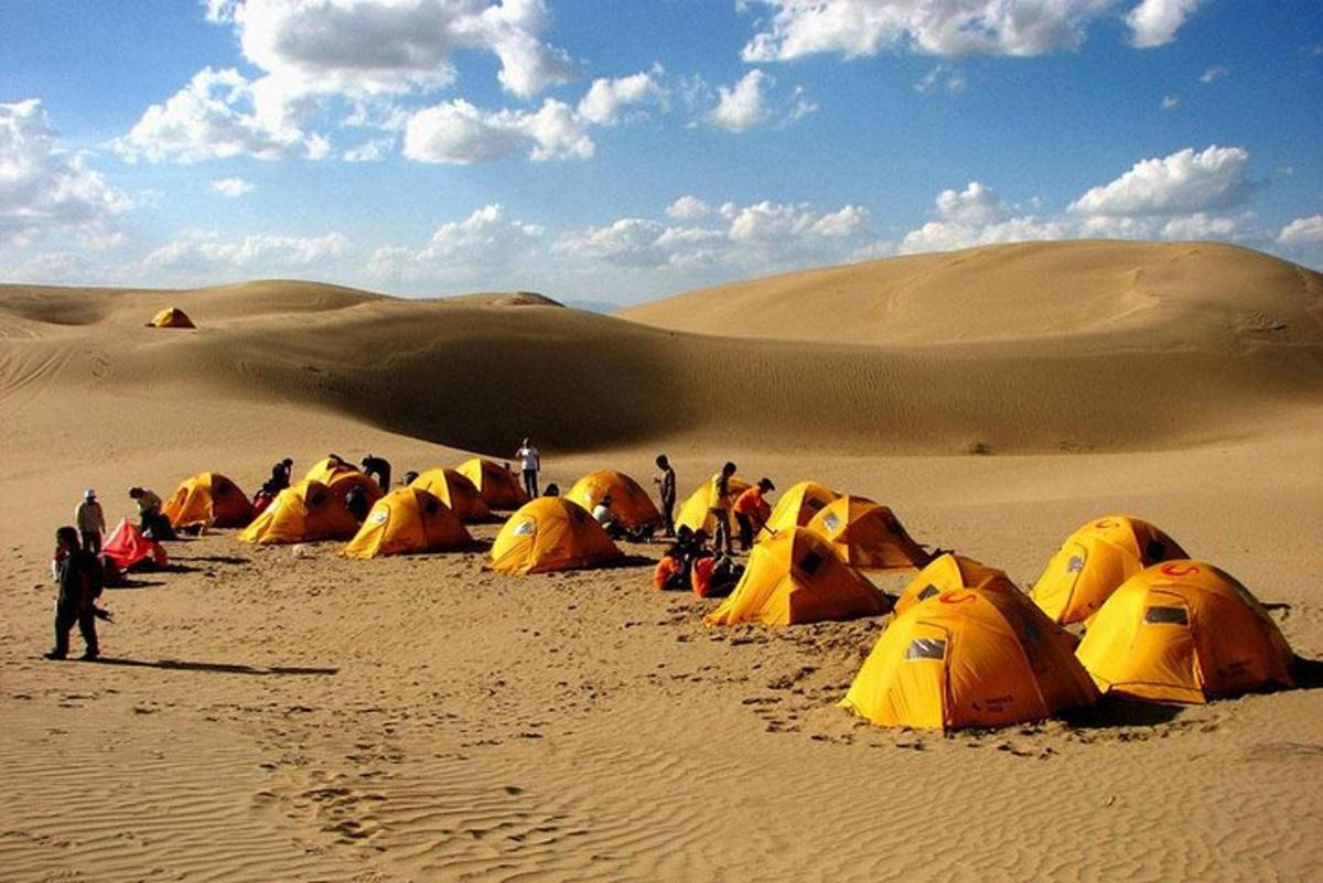 Un grupo de personas en un desierto con tiendas de campaña.