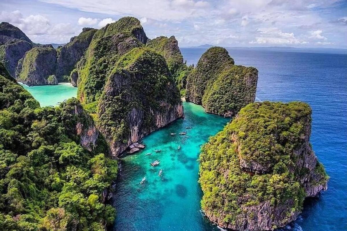sebuah pulau di lautan dengan air biru dan tebing hijau