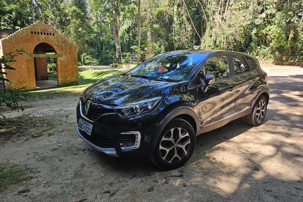 a black car parked on a dirt road