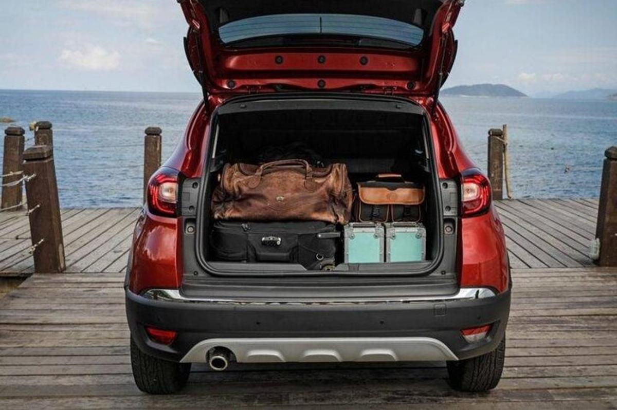 a red suv with its trunk open on a pier