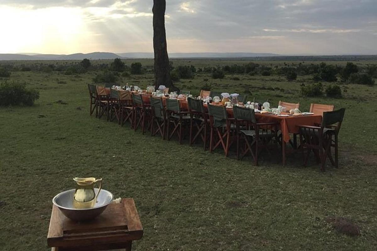 uma longa mesa posta para uma refeição em um campo