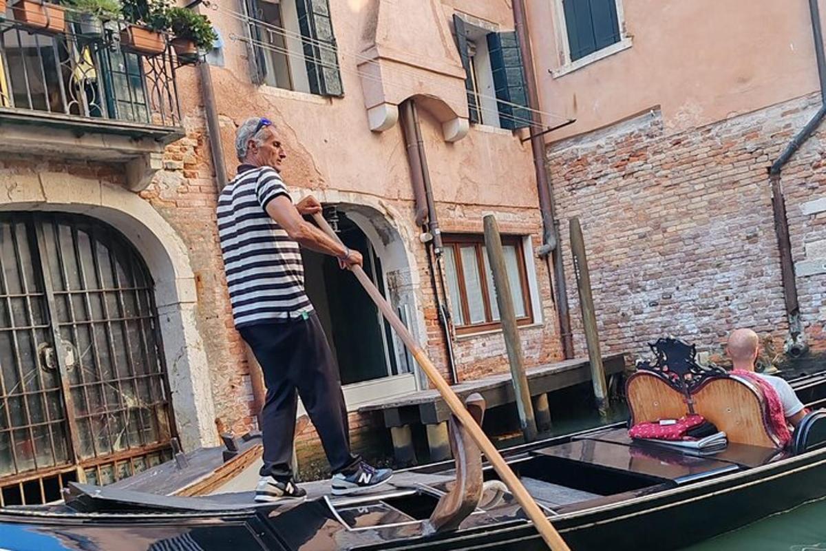 Un hombre está remando una góndola en un canal.