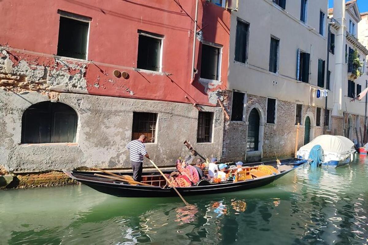 un hombre remando una góndola en un canal
