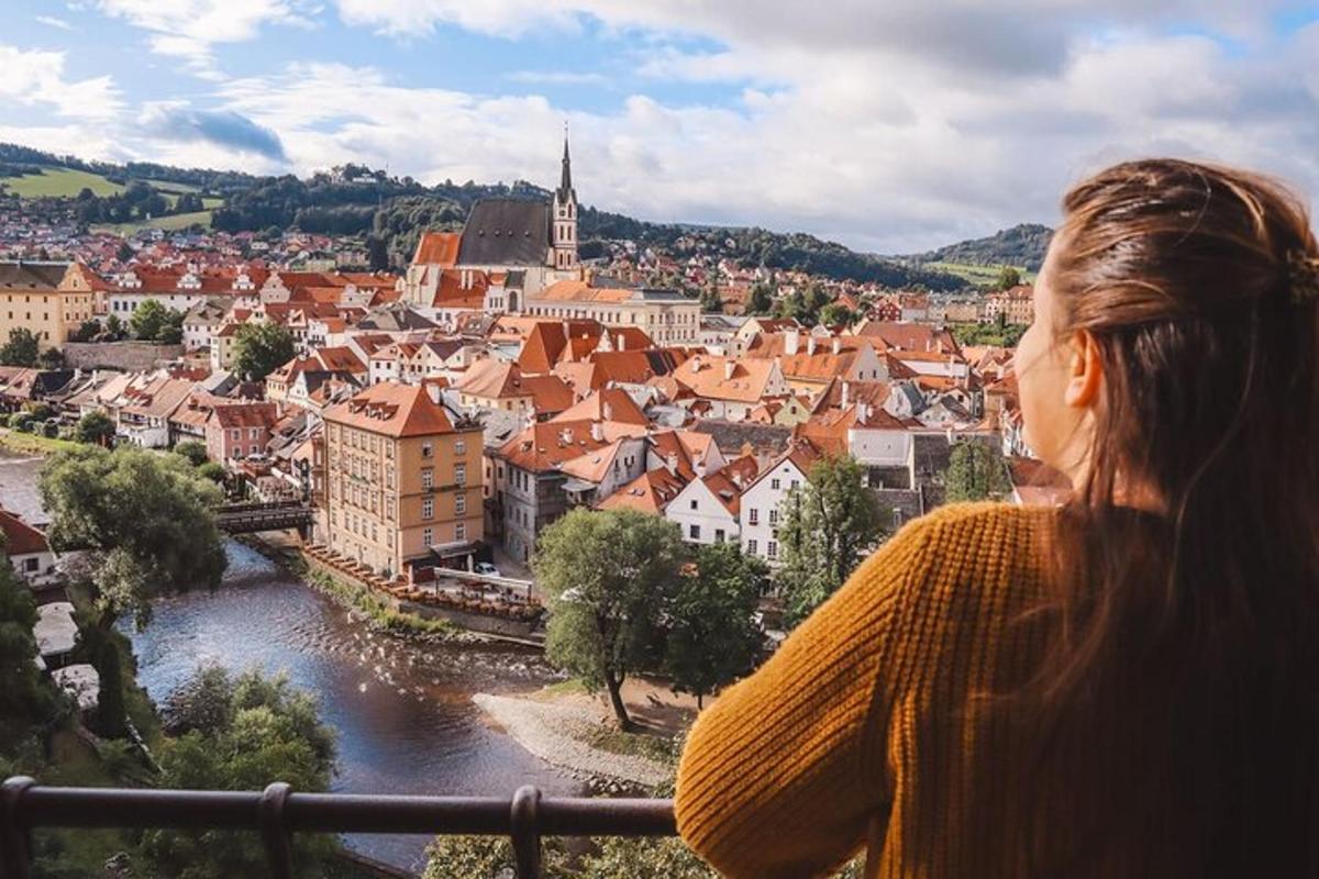 una donna in piedi su un balcone che guarda una città