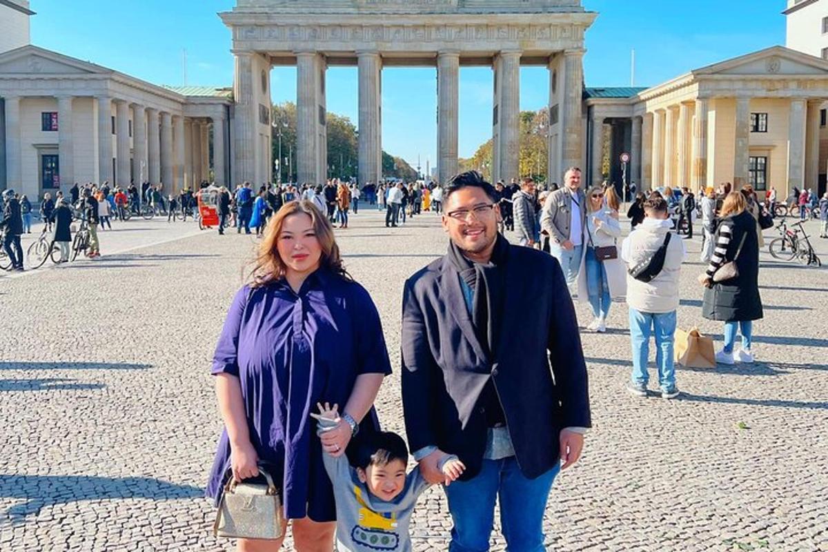 un uomo, una donna e un bambino in piedi davanti a un edificio