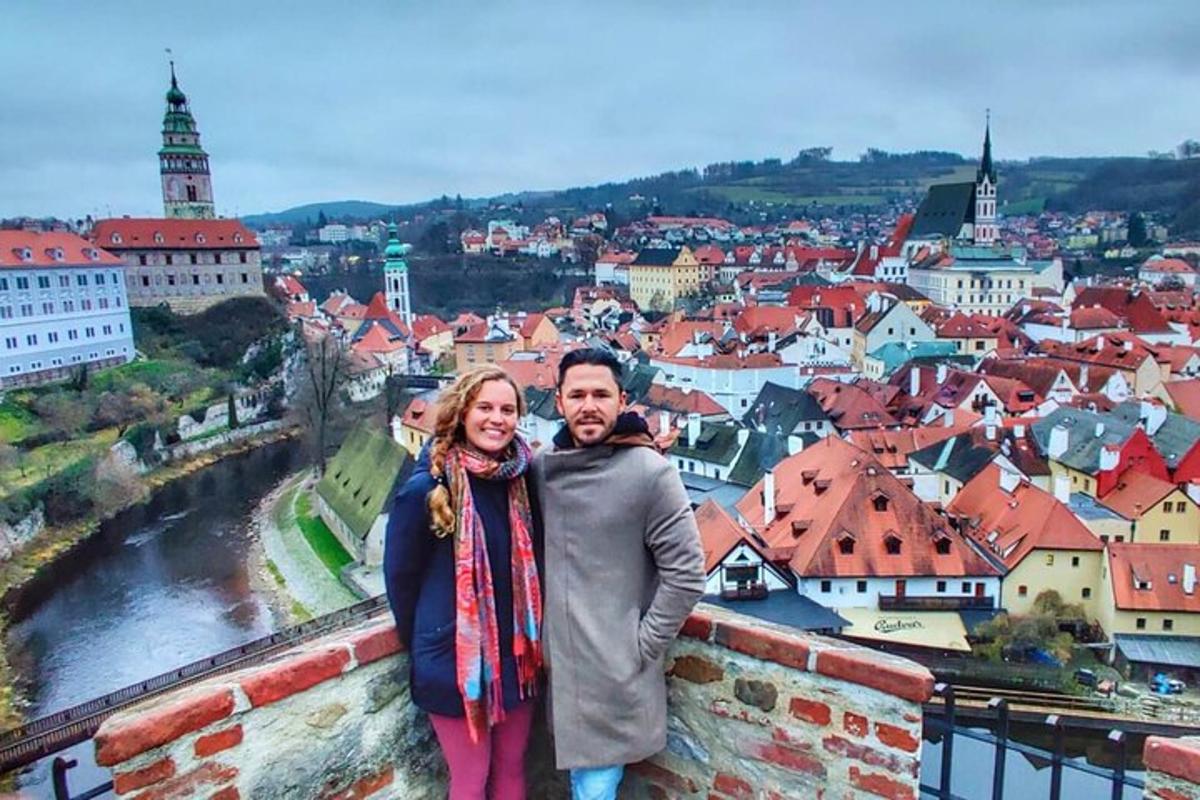 un uomo e una donna in piedi su un muro che domina una città