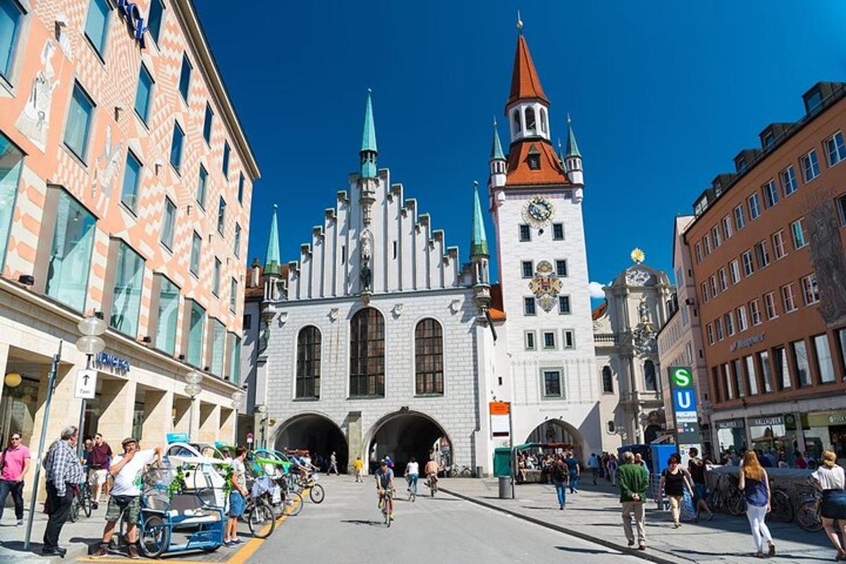 skupina ľudí prechádzajúcich sa po meste s hodinovou vežou
