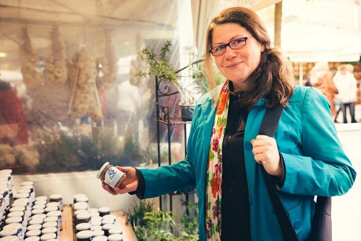 una donna in piedi davanti a un tavolo con in mano un orologio