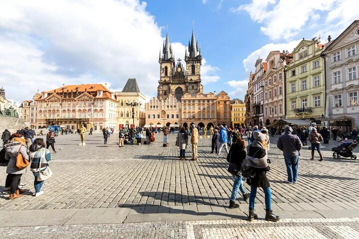 skupina lidí stojících na náměstí s katedrálou