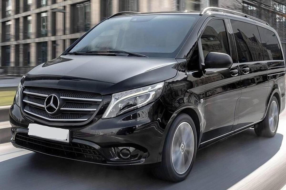 un furgone Mercedes Benz nero che percorre una strada