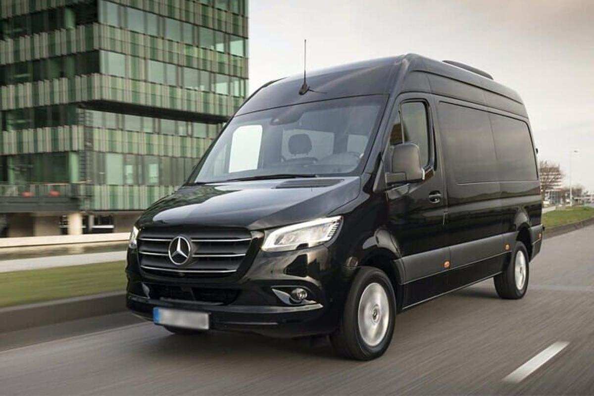 a black van is driving down a street