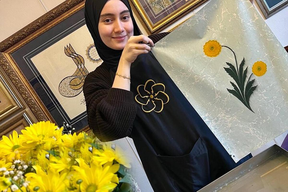 Kona í hijab heldur á flugdreka við hlið blóma