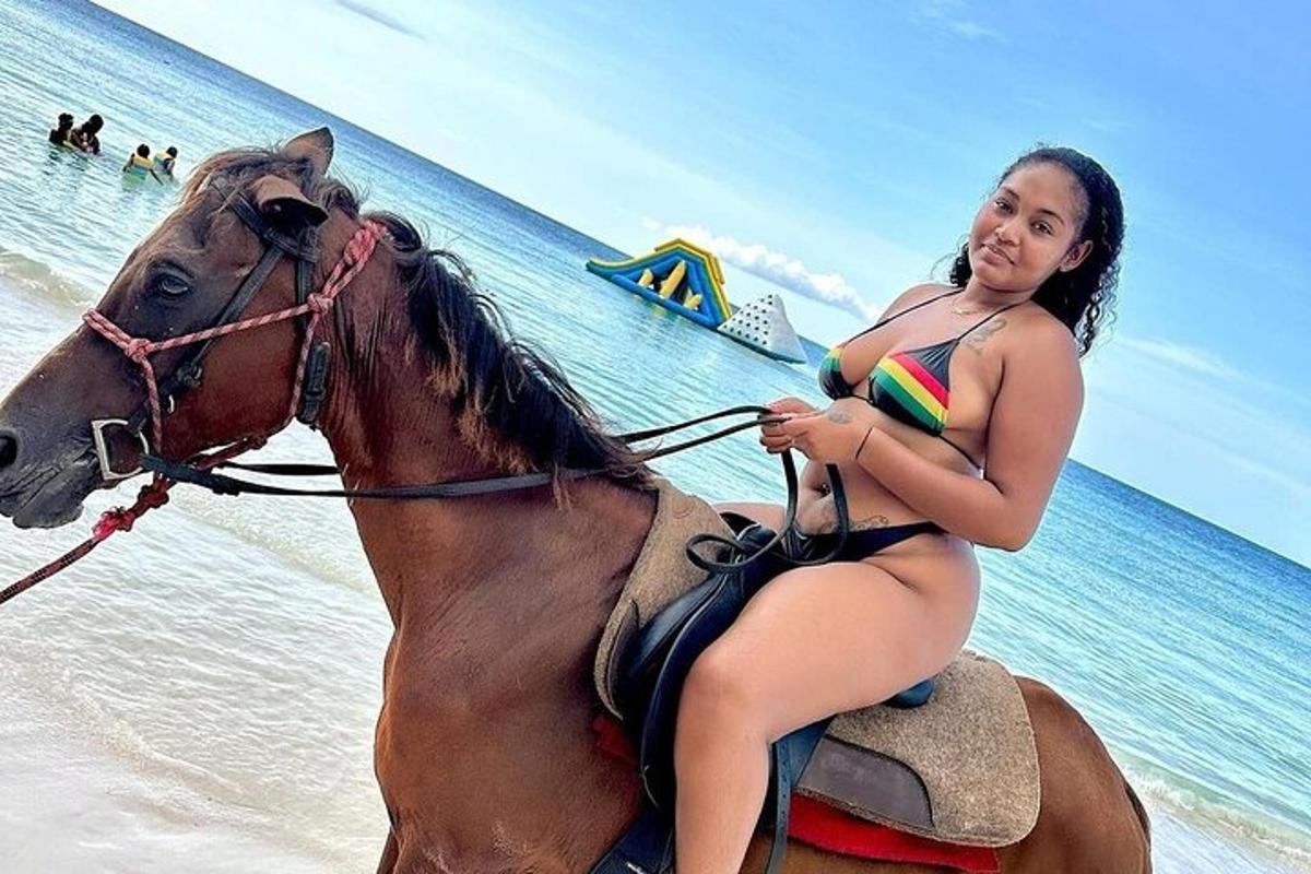 一名身穿比基尼的女子在海滩上骑马