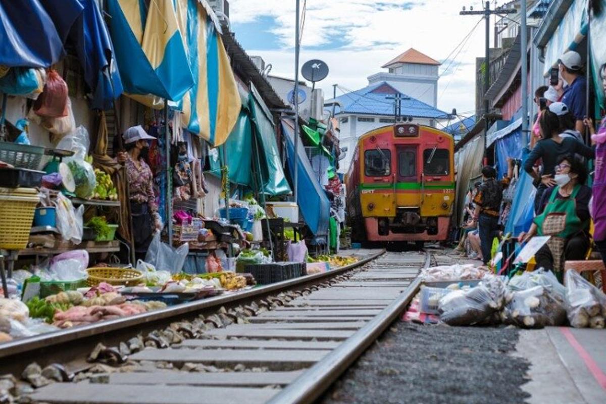 a train is going through an outdoor market with a train track
