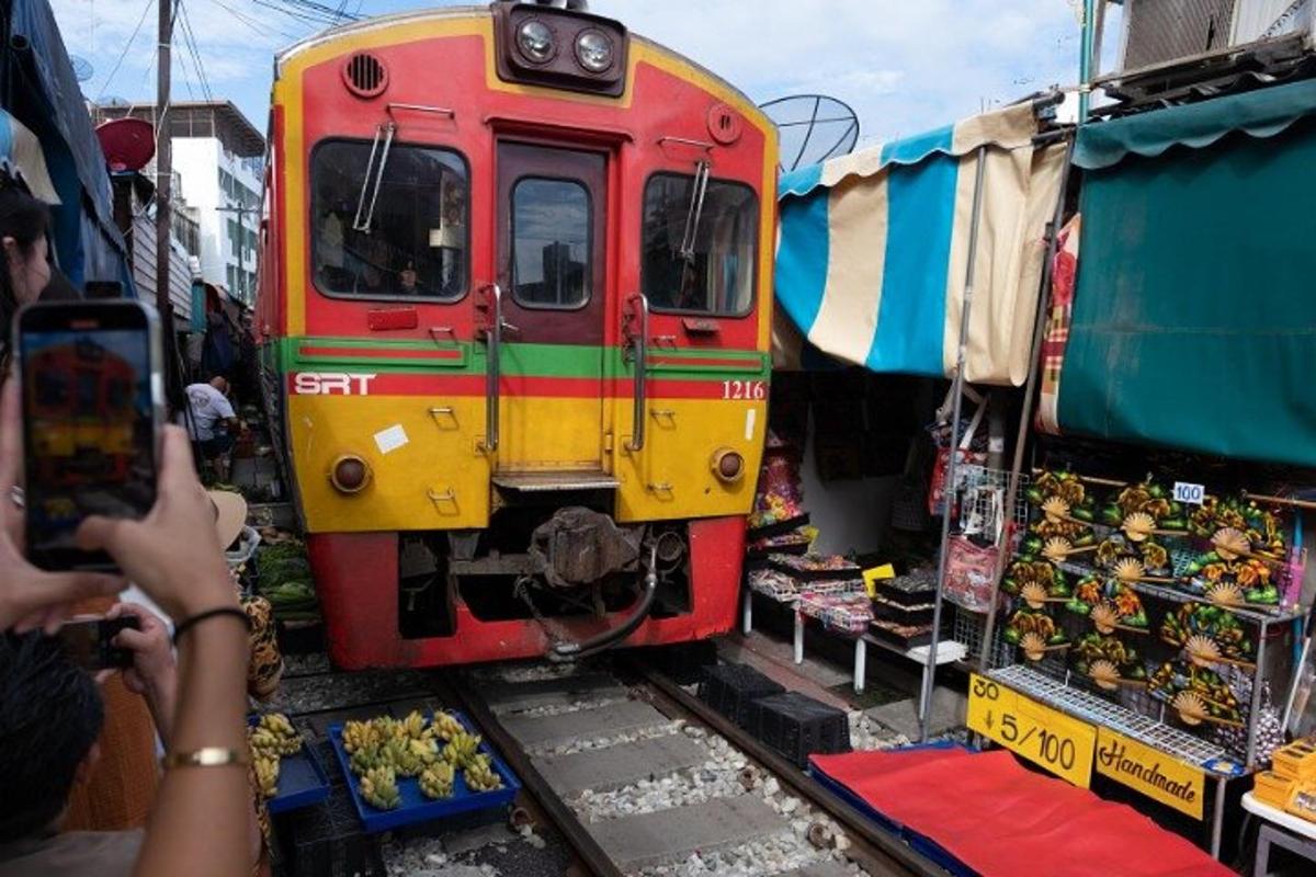 a person taking a picture of a train on the tracks