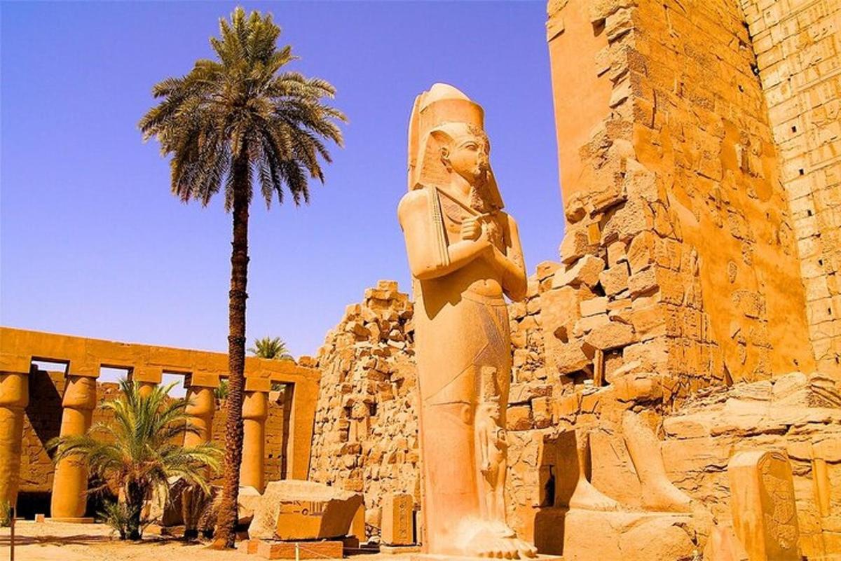 uma estátua em frente a um prédio com uma palmeira