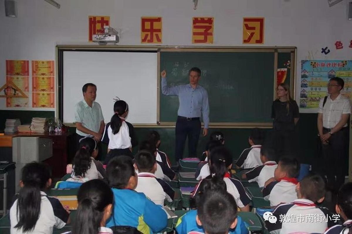 a man standing in front of a classroom of children