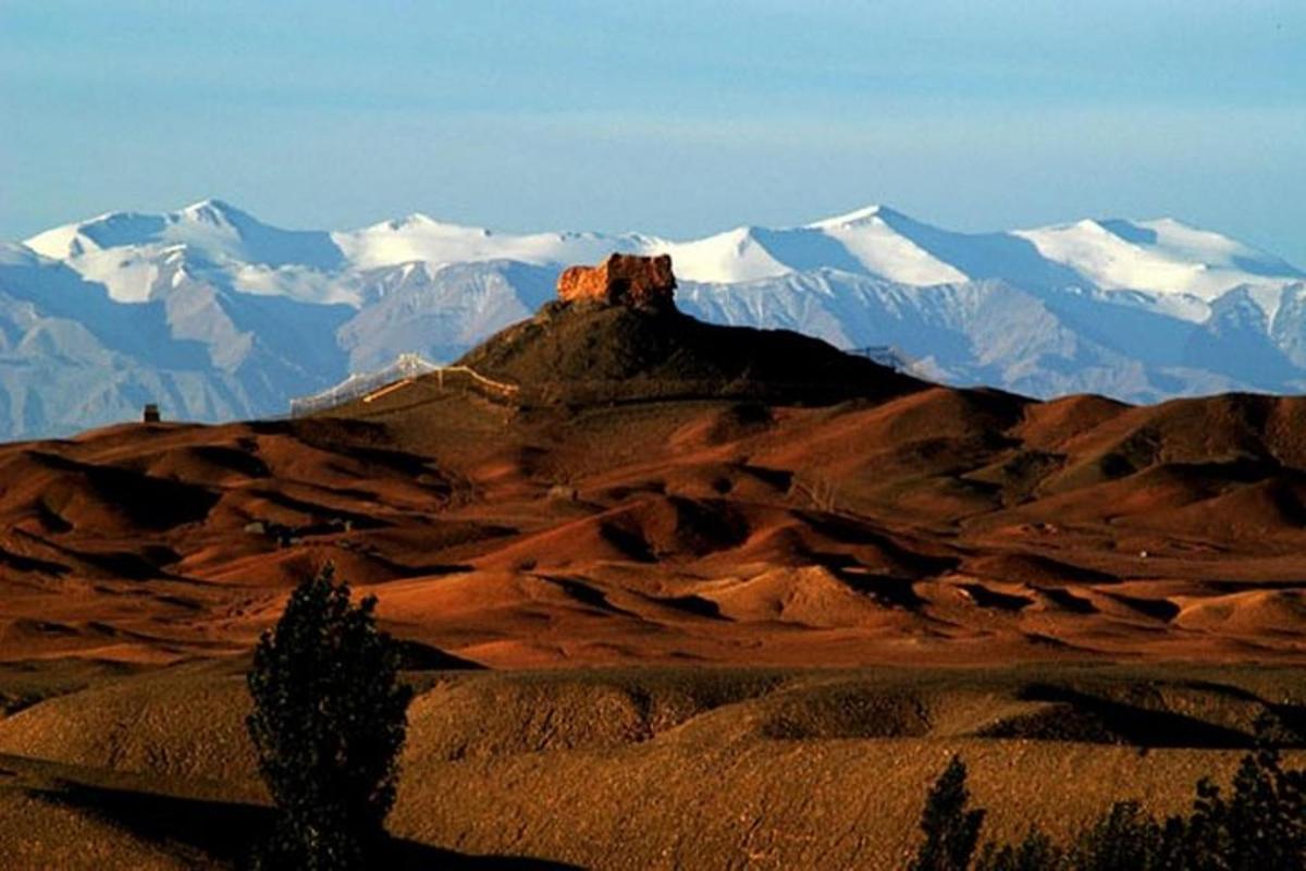a mountain range with snow capped mountains in the distance