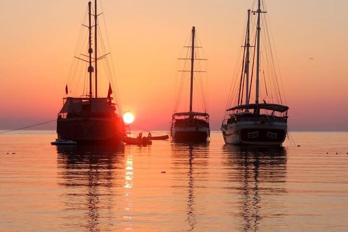 tři lodě sedící ve vodě při západu slunce