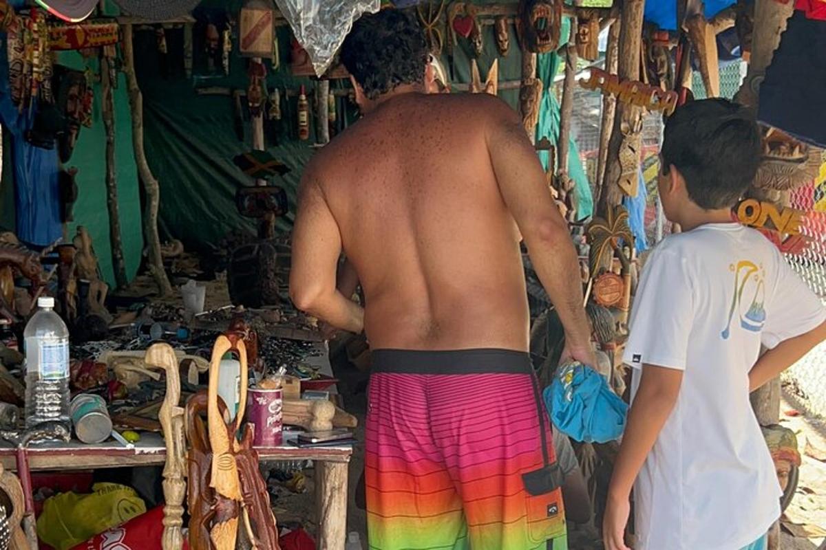 Un hombre sin camisa y un niño parados frente a una tienda