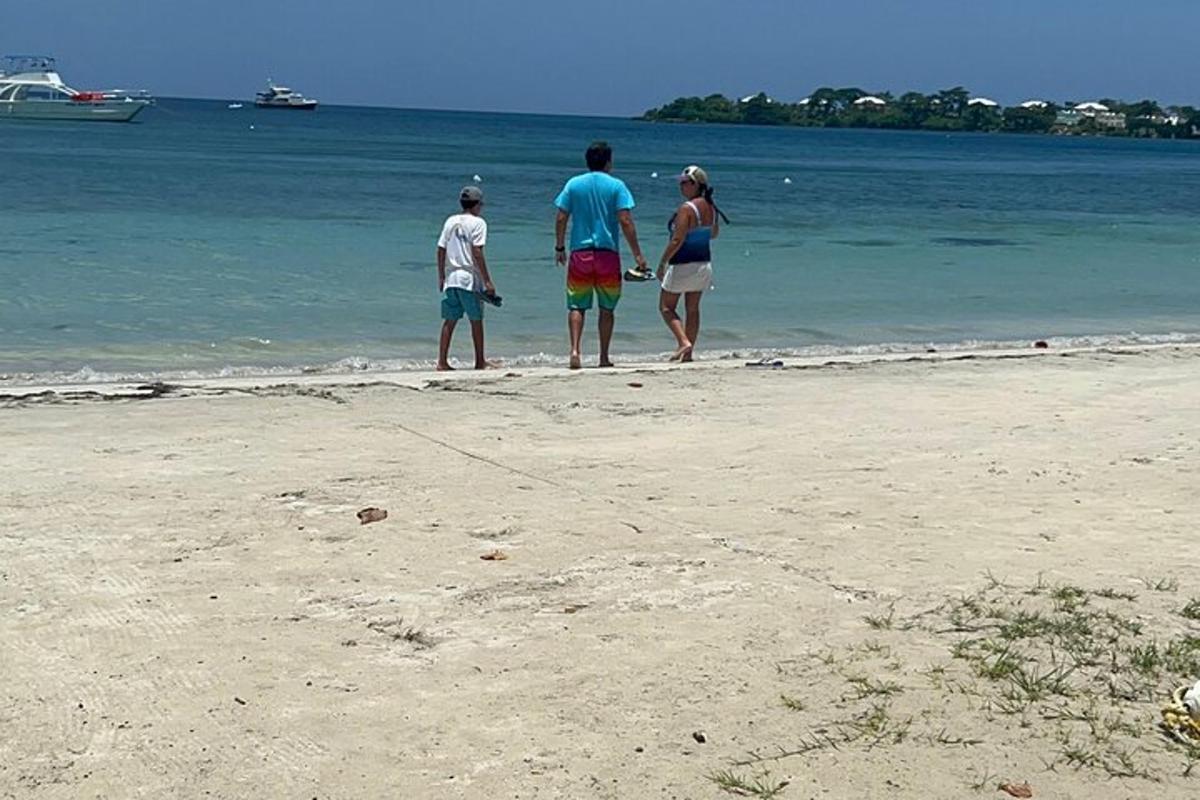 Un grupo de tres personas de pie en la playa
