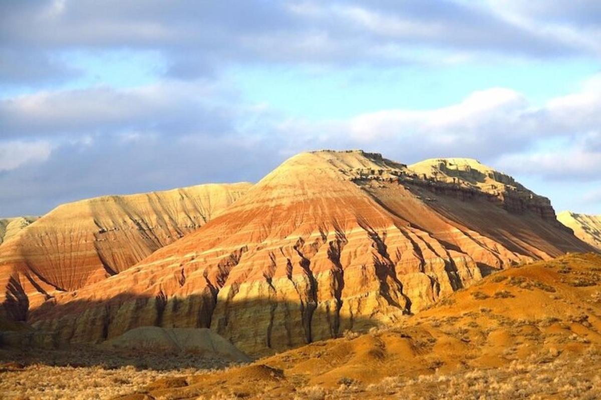 uma montanha no deserto com um céu nublado