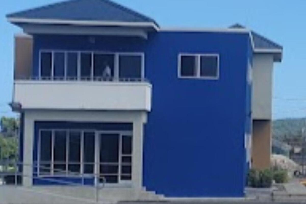 uma casa azul com uma varanda no topo