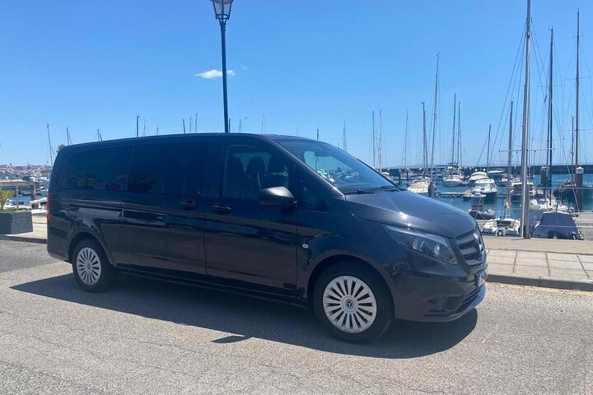 ein schwarzer Lieferwagen auf einem Parkplatz in der Nähe eines Yachthafens