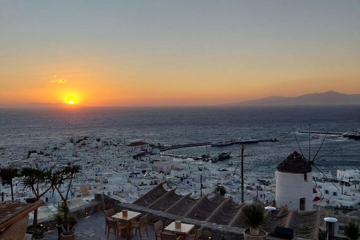 μια θέα μιας πόλης με τον ήλιο να δύει πάνω από τον ωκεανό