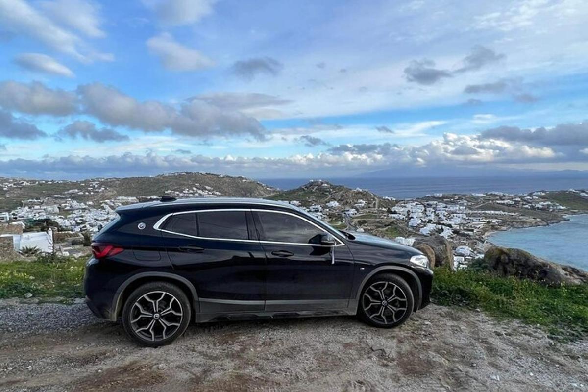 un'auto nera parcheggiata su una roccia vicino all'oceano