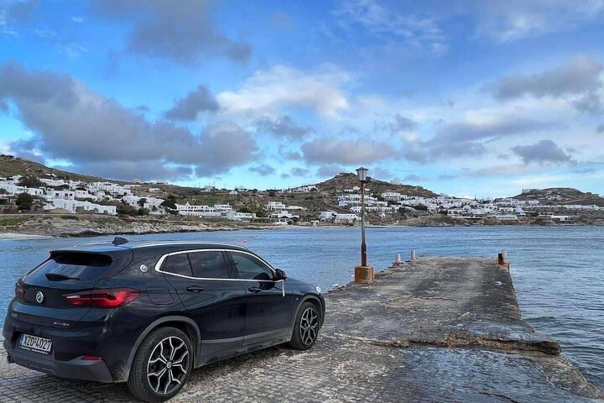un'auto parcheggiata su un molo vicino a uno specchio d'acqua