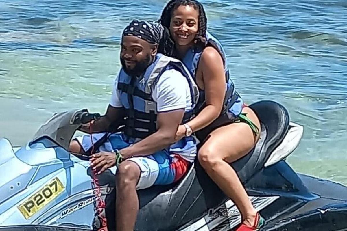 seorang lelaki dan seorang wanita duduk di atas jet ski di dalam air