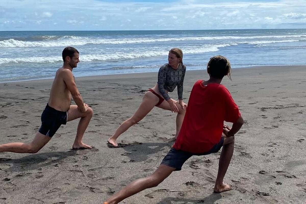 tři lidé si hrají s frisbee na pláži