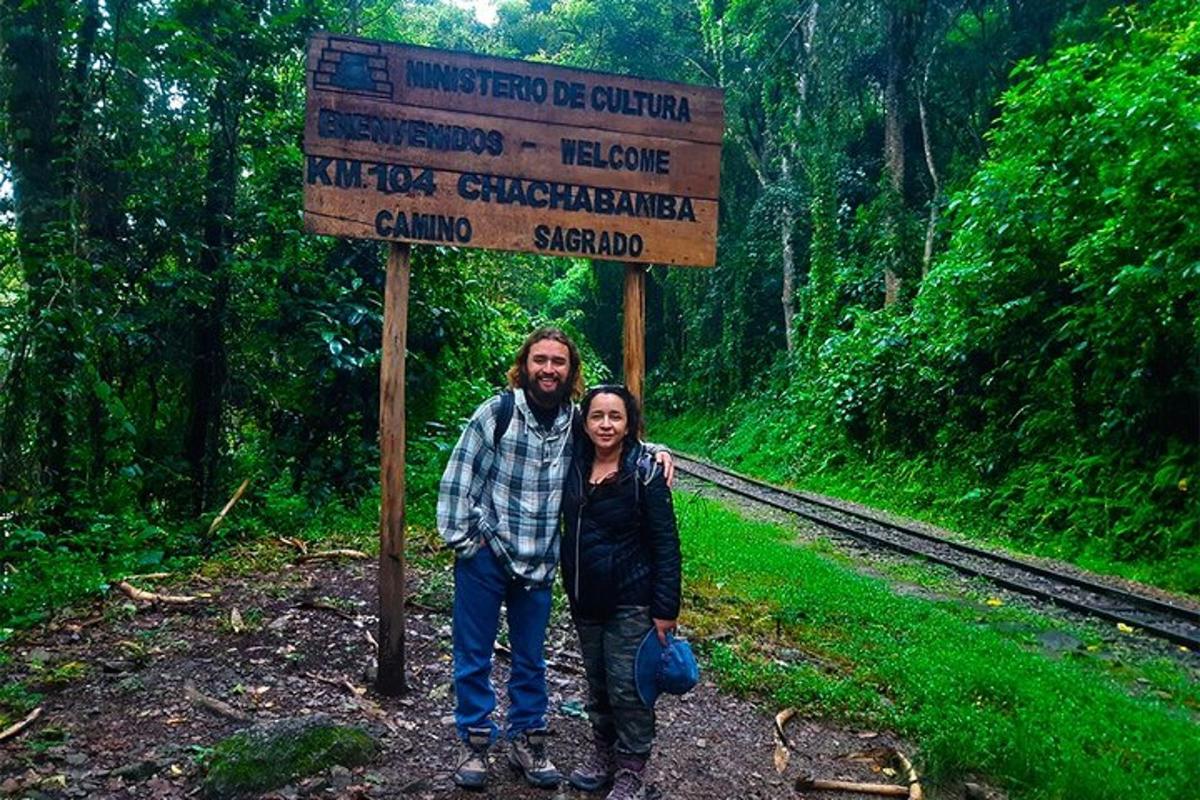 Un hombre y una mujer de pie frente a un cartel