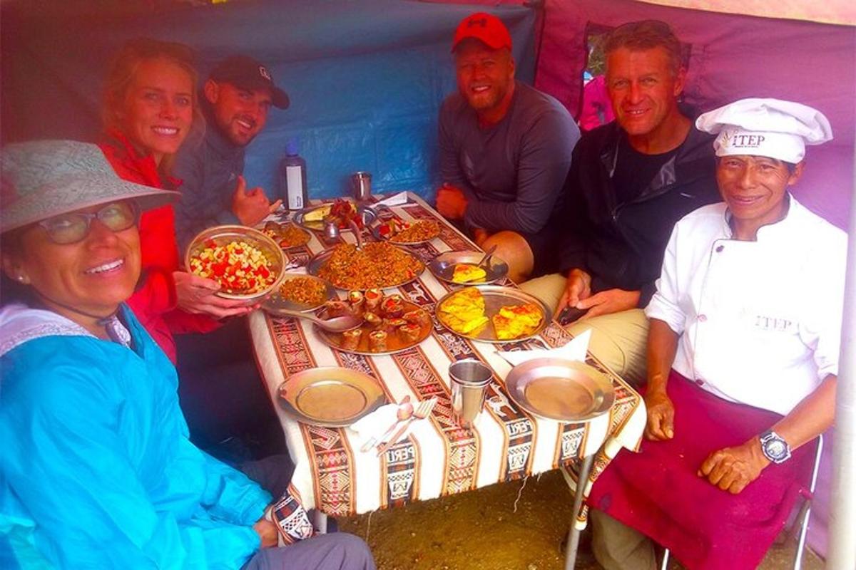 Un grupo de personas sentadas alrededor de una mesa con comida.