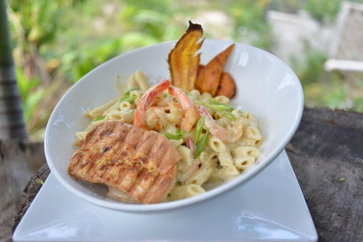 un bol de pasta amb gambes i verdures a la taula