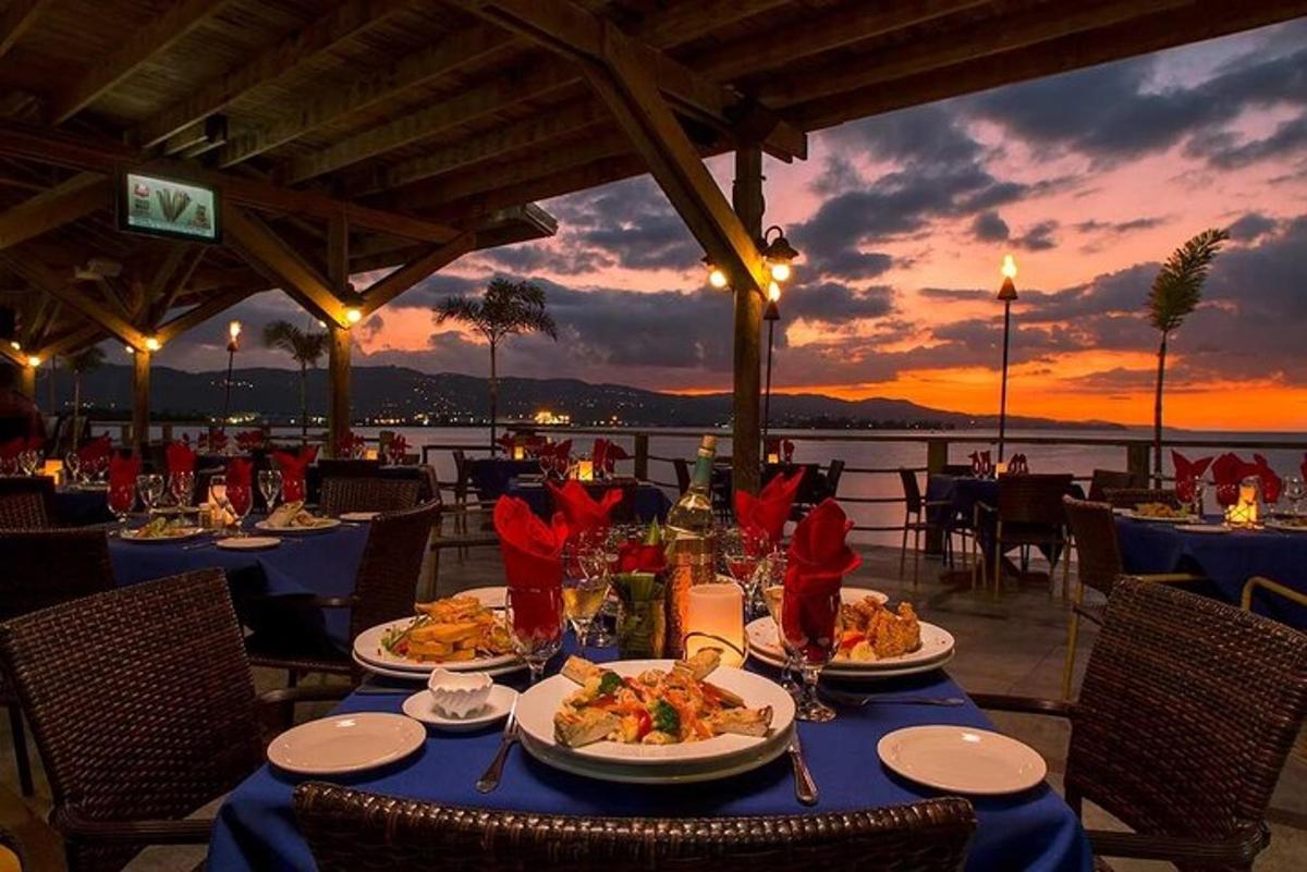 ein Tisch mit Tellern voller Essen darauf und einem Sonnenuntergang