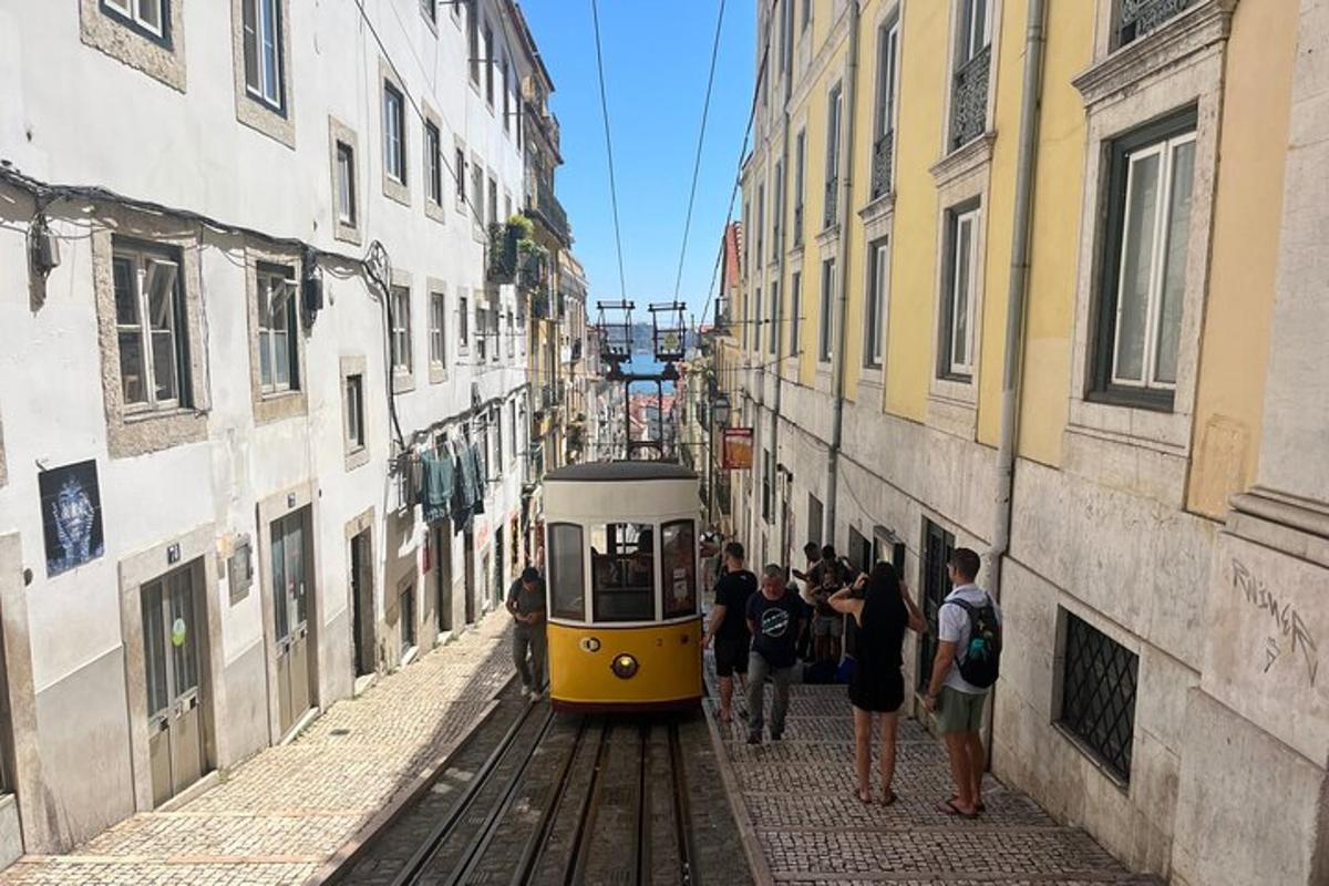 um trem amarelo e branco viajando por uma rua estreita