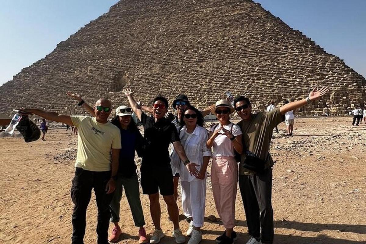skupina lidí stojící před pyramidou