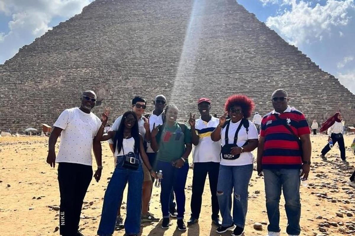 skupina lidí stojící před pyramidou